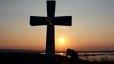 stock-footage-silhouette-of-man-praying-under-the-cross-at-sunset-sunsrise