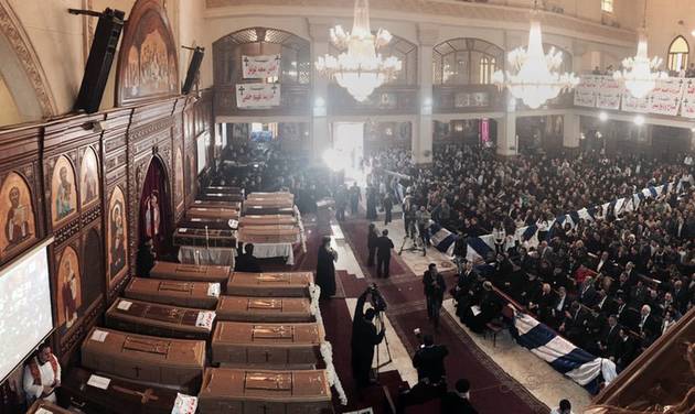 People attend a funeral service for victims of a Sunday cathedral bombing, at the Virgin Mary Church, in Cairo, Egypt, Monday, Dec. 12, 2016. Egyptians held prayers for 25 Christians killed the day before at a church next to the city's main Coptic cathedral in what was one of the deadliest attacks on the religious minority in recent memory. The bomb went off while worshippers were attending Sunday Mass at a chapel adjacent to St. Mark's Cathedral. The coffins of the 25 have been laid in front of the altar, with the names of each victim plastered on the side facing the congregation. (AP Photo/Nariman El-Mofty)